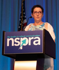 NSPRA award winner Susan Brott speaking at the podium of an NSPRA Seminar.